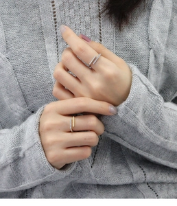 Detail of gold and silver minimalist open rings with micro-pave diamonds on a knit sweater