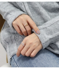 Close-up of dual-band adjustable ring with pave stones on a grey knit background