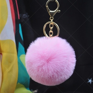 Detailed view of pink faux rabbit fur keychain with a gold metal ring and chain attachment
