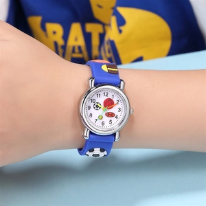 Detail of blue children's watch with 3D soccer and basketball patterns on wrist