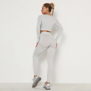 Detail of light gray seamless yoga set showing high waist leggings and long sleeve crop top