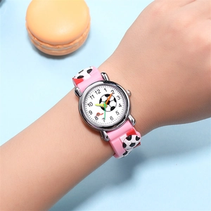 Detailed view of pink silicone strap with 3D embossed football pattern on child's wrist