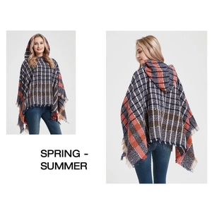 Detail of plaid hooded poncho featuring orange and blue checks with fringed edges