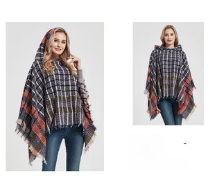 Detail of hooded knit poncho showing colorful plaid pattern and fringe trim finish