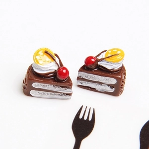 Macro view of miniature resin chocolate cake with lemon slice and cherry for DIY crafts