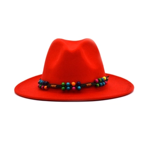 Detail of red wool fedora hat featuring a colorful ethnic beaded band and wide brim