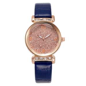 Detailed close-up of rose gold watch with crystal-encrusted dial and blue leather strap