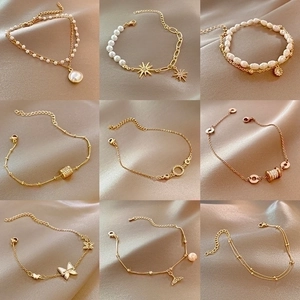Detalle de 9 estilos de pulseras doradas con perlas, mariposas y motivos de estrellas