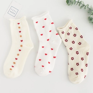 Three pairs of white cotton mid-calf socks with red heart and floral patterns