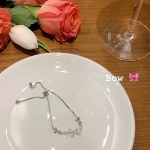 Detalle de pulsera de mariposa plateada ajustable con cristales pavé brillantes