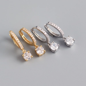 Macro shot of gold and silver S925 sterling silver hoop earrings with round zircon charms