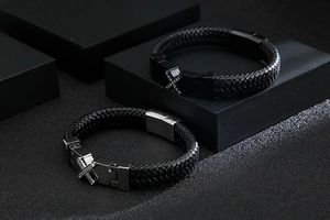 Macro shot of men's braided leather bracelet with diamond-set cross metal buckle detail