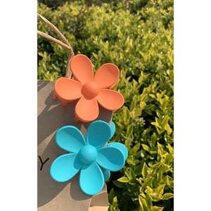 Floral hair claw clips in orange and blue resin with a matte finish for hair styling