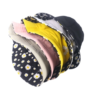 Various colors of daisy print and solid bucket hats arranged on white background