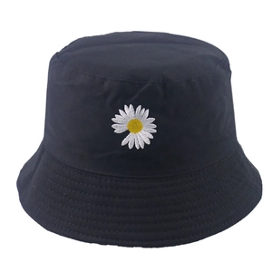Detailed view of daisy flower embroidery on a black cotton bucket hat with white petals