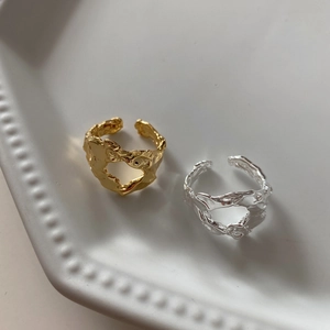 Close-up of irregular hollow lava texture on gold and silver 925 silver open rings