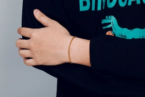 Close-up of a gold stainless steel O-chain bracelet worn on a man's wrist