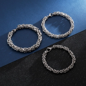 Three men's interlocking woven titanium steel bracelets in silver finish shown on a dark base
