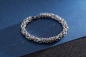 Close-up of interlocking woven titanium steel link bracelet with lobster clasp