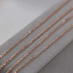 Set of four rose gold stainless steel cable chain necklaces on a grey velvet display