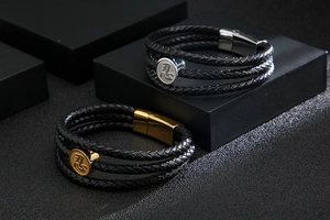 Detail of multi-layer braided leather bracelet featuring engraved Kanji character metal disc