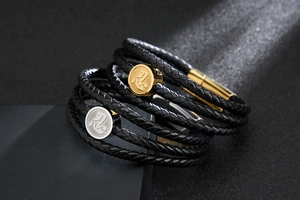 Close-up of stacked braided leather bracelets with gold and silver Kanji engraved charms