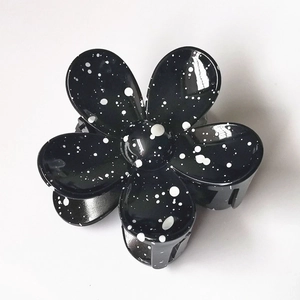 Detail of flower hair claw clip in black with white ink pattern and glossy finish