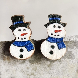Macro view of handmade wooden snowman earrings with festive blue scarf and black hat
