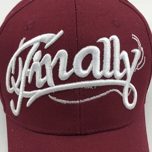 Close-up of 3D Finally white embroidery on a burgundy cotton twill baseball cap