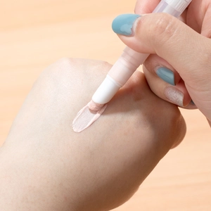 Portable twist-up cosmetic pen with sponge applicator and liquid foundation on hand