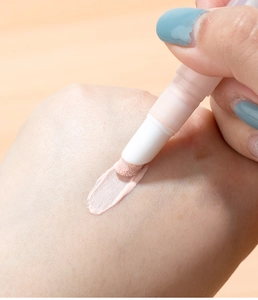 Detailed close-up of a sponge tip applicator applying liquid concealer onto the skin