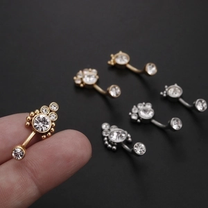 Zircon belly rings in gold, silver, and rose gold finishes shown on black background