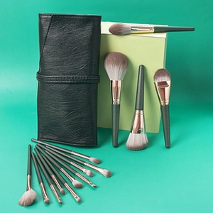 Detail of 12 professional makeup brushes with rose gold ferrules and leather pouch