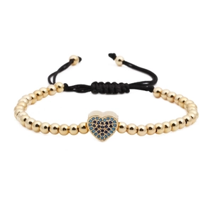 Woven bead bracelet with heart pendant featuring blue zircon and gold finish on white background