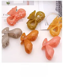 Detail of six colorful matte resin butterfly hair clips in candy colors for hair styling