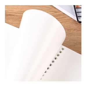 Minimalist white spiral notebook with blank inner pages on light wood textured desk