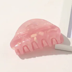 Detail of pink acetate hair claw with gold foil flakes and smooth rounded teeth finish