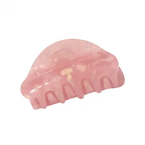 Detail of light pink acrylic hair claw clip with golden flakes and crescent design