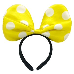 Macro detail of large yellow headband with white polka dots and oversized fabric bow