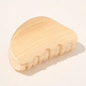 Macro detail of a yellow marble patterned acetate hair claw clip with smooth polished finish