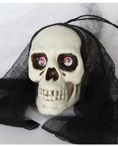 Gros plan d'un crâne décoratif d'Halloween avec voile noir et détails des yeux rouges