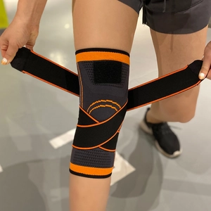 Détail de la genouillère de compression avec sangles croisées orange pour le sport
