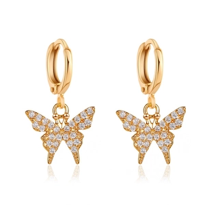 Boucles d'oreilles créoles papillon dorées avec pavé de zircons blancs sur fond blanc