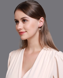 Détail de boucles d'oreilles papillon dorées avec cristaux étincelants sur un mannequin