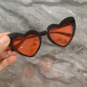 Détail de lunettes de soleil coeur pour enfants avec monture noire et verres
