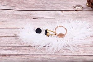 Close-up of minimalist gold, silver, and rose gold rings on a soft white feather base