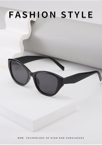 Gros plan de lunettes de soleil œil de chat noires sur un support blanc géométrique
