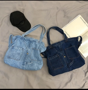 Detailed flat lay of light and dark blue denim tote bags with vintage pockets and buttons
