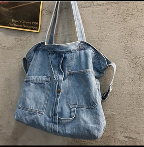 Retro denim tote bag for women featuring creative jeans pocket design on a cement wall
