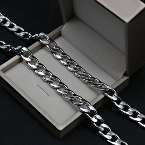Silver stainless steel Cuban link chain necklace displayed on champagne jewelry box